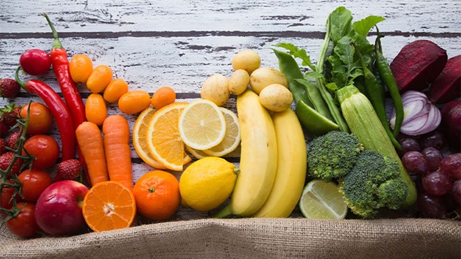 Fruta e legumes frescos em cima de superfície de madeira