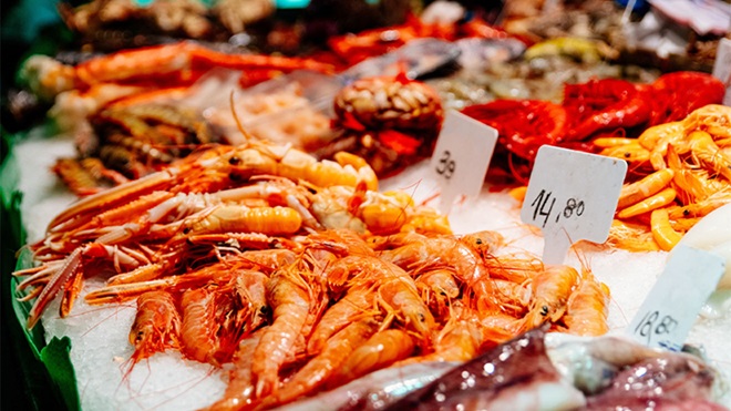 Banca de marisco no mercado com gambas em cima de gelo