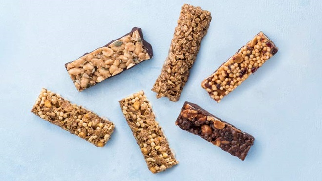 Várias barras de cereais sobre um fundo azul claro