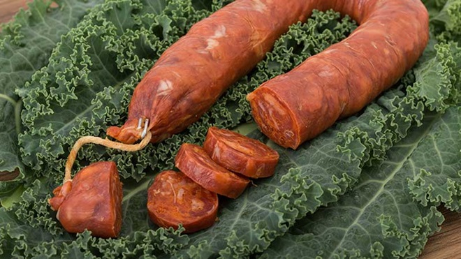 Chouriço de carne em cima de uma folha de couve
