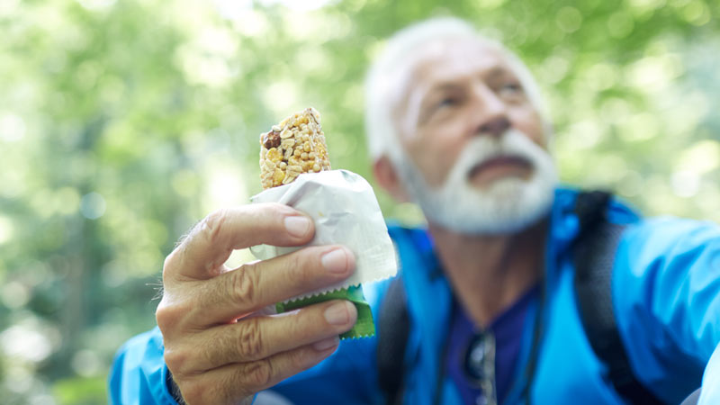 adulto a comer uma barra de cereais 