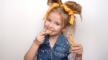 criança a comer uma barra de cereais
