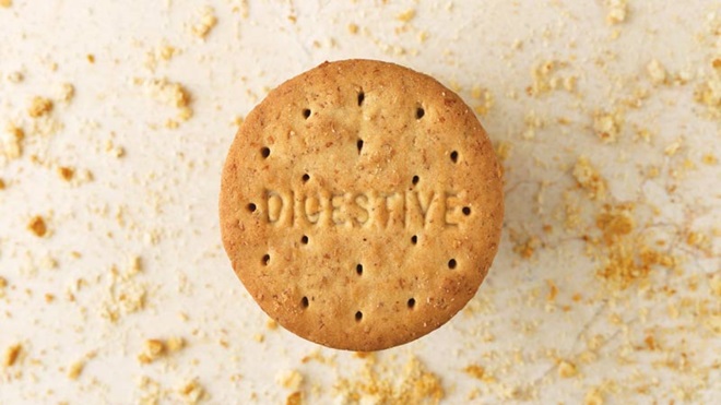 Bolacha digestiva sobre uma mesa com migalhas de bolacha à volta