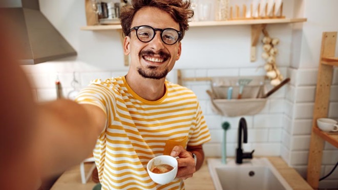 Jovem a tomar café em casa