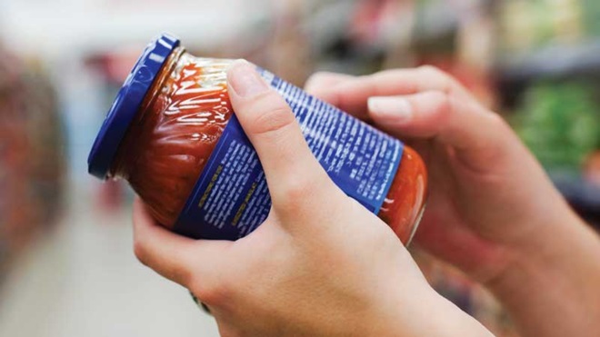 Mulher a ver rótulo de frasco