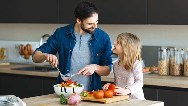 Pai e filha a prepararem uma salada