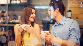 homem e mulher no café com chávenas na mão