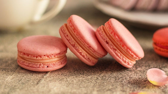 3 macarons cor de rosa em cima de uma mesa