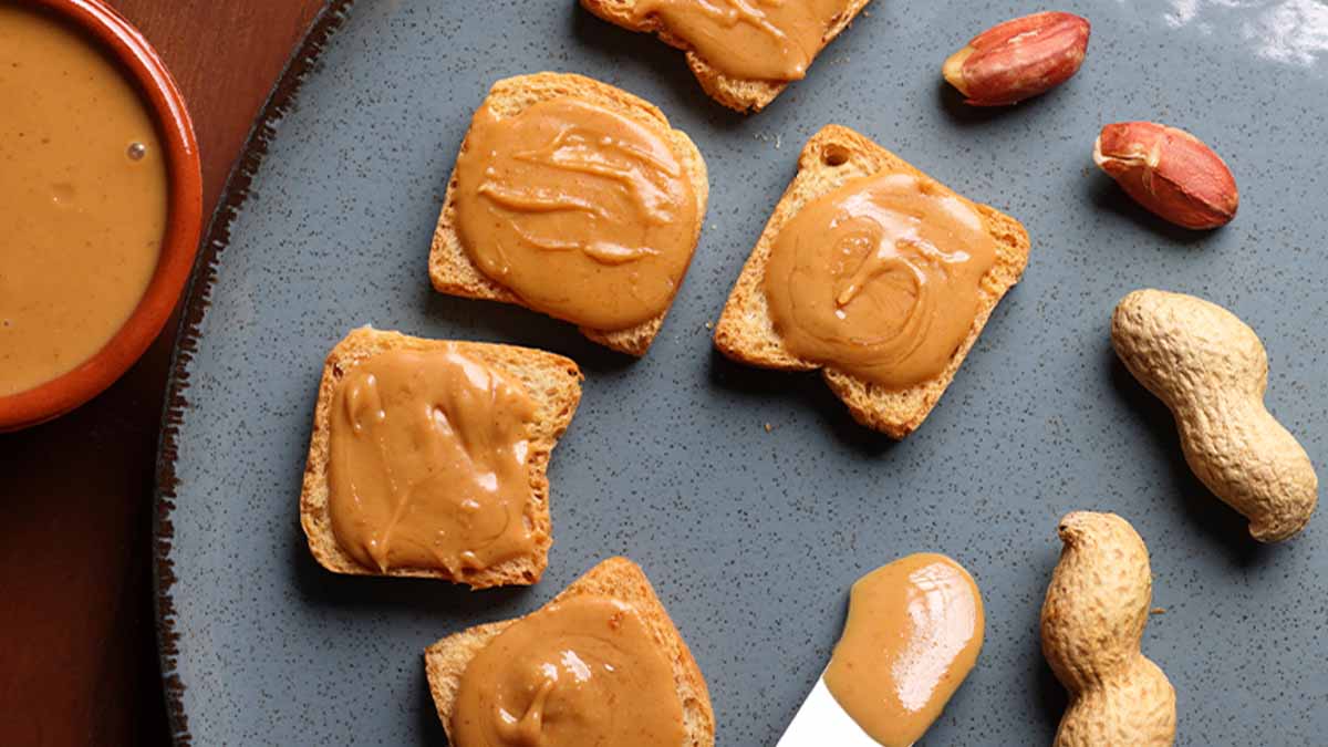 Tostas dispostas num prato cinzento com creme de amendoim por cima