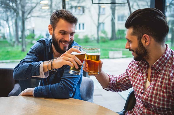 Dois amigos brindam com cerveja sem álcool