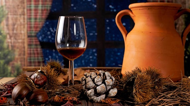 Copo de jeropiga com castanhas, pinhas e ânfora de barro