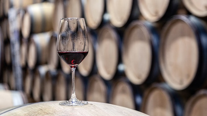 Cálice de vinho do Poto com barricas de madeira como pano de fundo