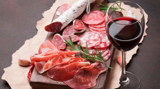 Tábua com enchidos e copo de vinho tinto
