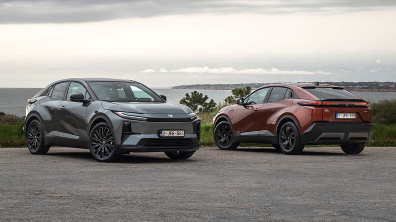 Dois Toyotas CHR+, um cinzento de frente e outro vermelho de trás