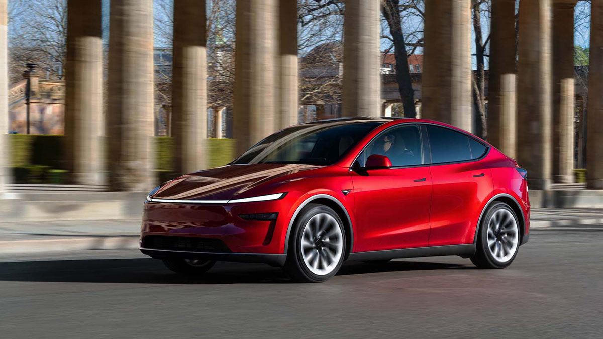 Automóvel Tesla Model Y Premium vermelho na estrada com colunas atrás