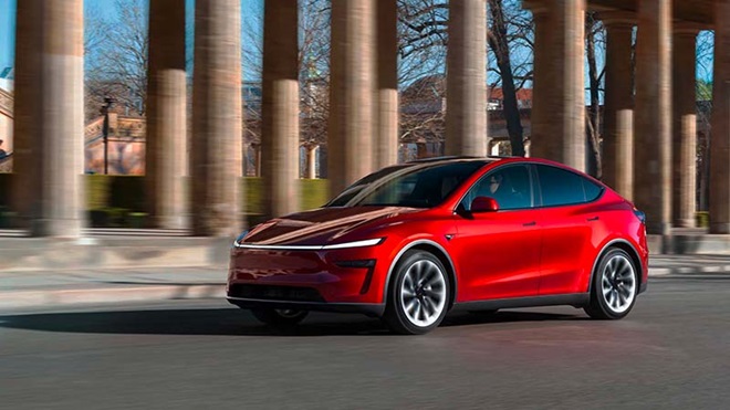 Automóvel Tesla Model Y Premium vermelho na estrada com colunas atrás