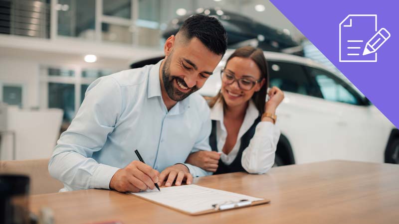 Casal a assinar contrato de compra de carro