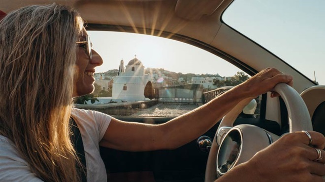 Mulher a conduzir um carro com ar satisfeito