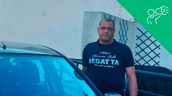 Fotografia de um senhor de tshirt ao lado do seu Honda Civic
