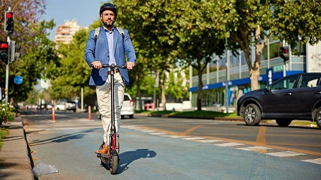 Homem a ir para o trabalho de trotinete