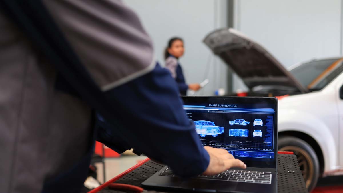 Mecânico a verificar ferramenta de diagnóstico automóvel em oficina