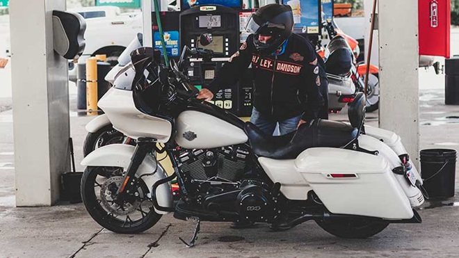 Motociclista de capacete a abastecer