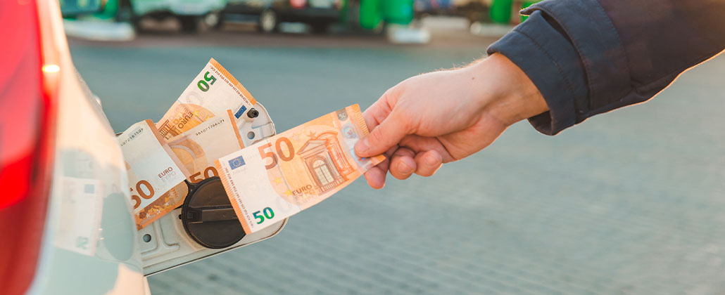 Pessoa a inserir notas de 50 euros no depósito de combustível de automóvel