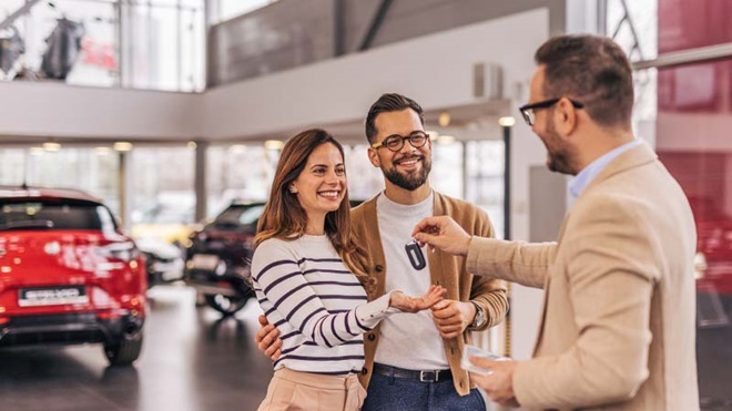 Casal a receber a chave do carro no stand