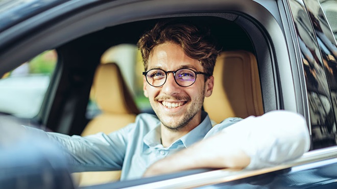 Rapaz sentado ao volante do carro
