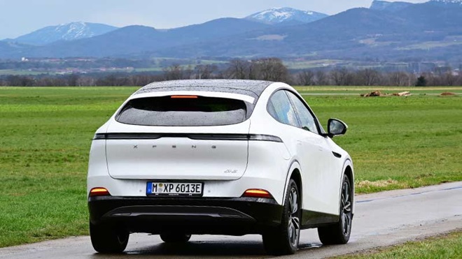 Xpeng G6 branco, suv coupé elético, visto de trás na estrada