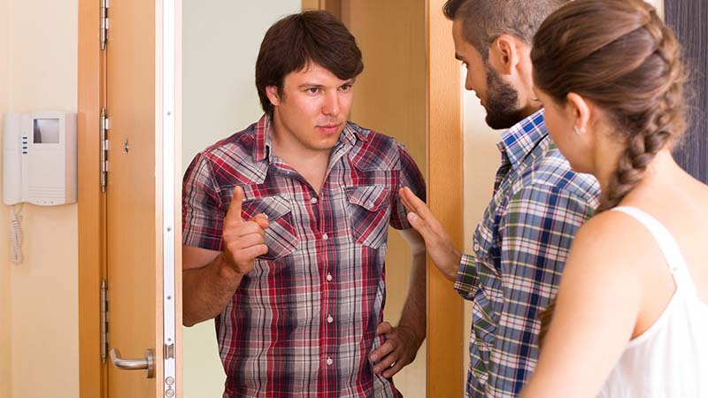 Homem à porta de casa a falar com um casal na entrada da casa