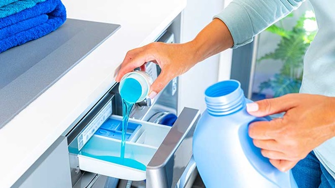 Mulher a colocar detergente na máquina