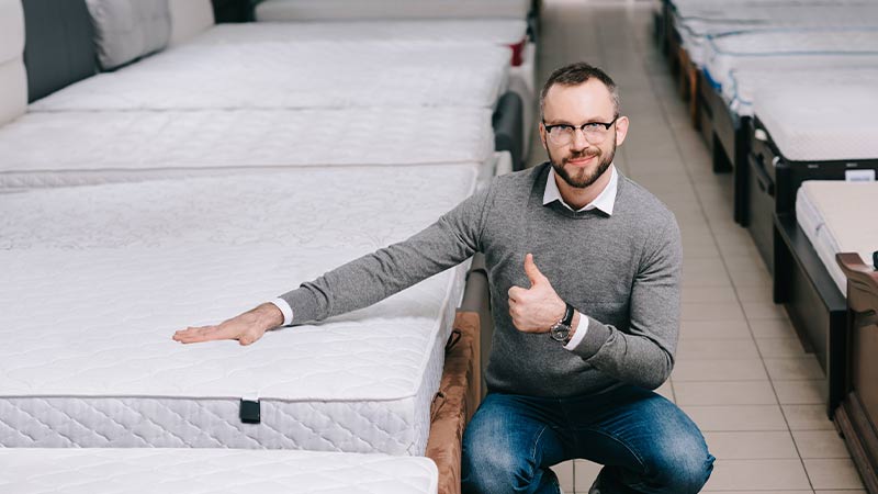 Homem a testar um colchão numa loja