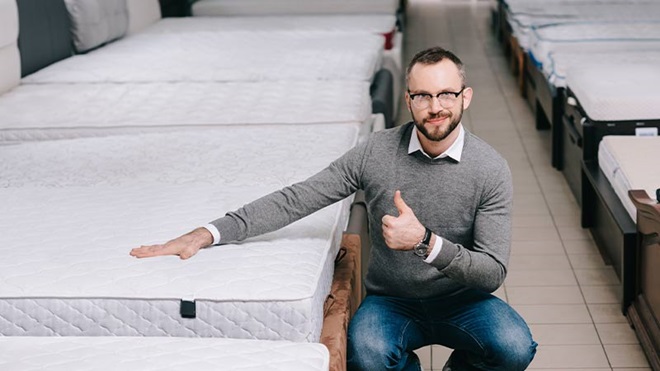 Homem a testar um colchão numa loja