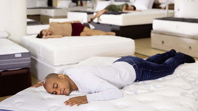 Pessoas a dormir em colchões numa loja