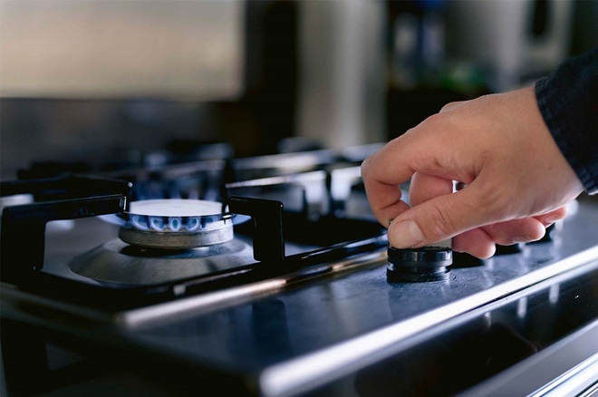 Pessoa a acender bico de gás de fogão