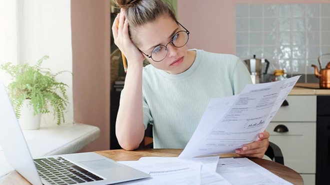 Mulher à mesa com laptop a analisar faturas de energia