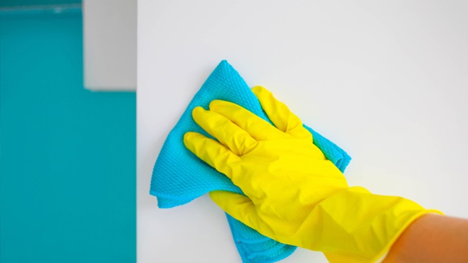 pessoa a limpar parede com um pano