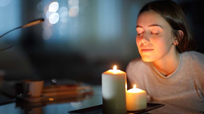 Grande plano de rosto de jovem à luz de duas velas