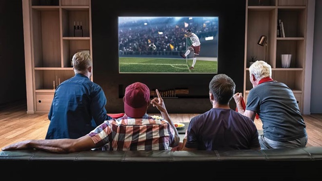 grupo de amigos a ver futebol na tv