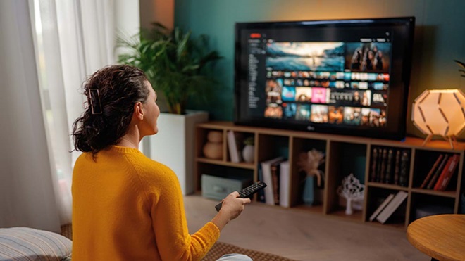 Mulher na sua sala a ver televisão