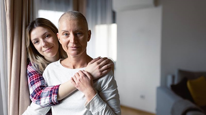 Mulher doente oncológica com a filha, numa sala