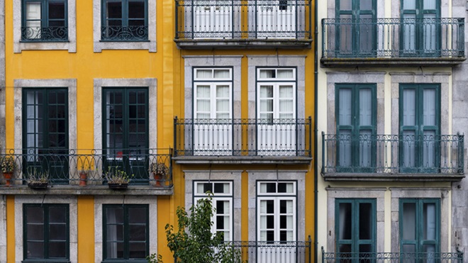 Três prédios com fachadas amarela e branca e varandas disponíveis para arrendamento