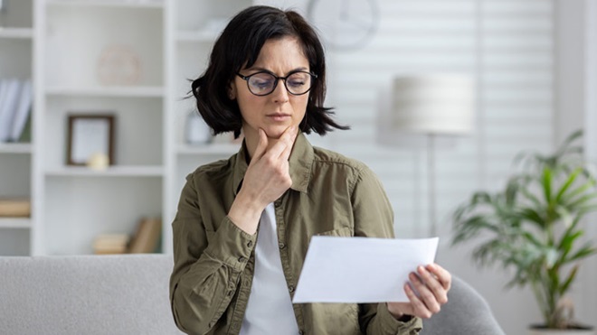 Mulher a olhar confusamente para um documento