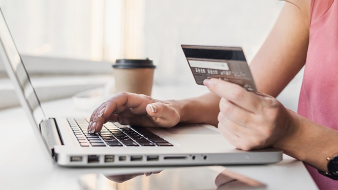 mulher no computador portátil a inserir dados do cartão de crédito