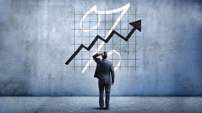 Homem a olhar para um gráfico na parede sobre o aumento de percentagem