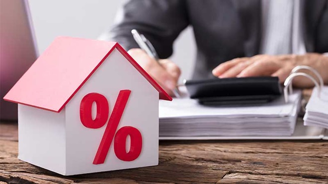 Homem com dossiê, calculadora e casa com o símbolo de percentagem