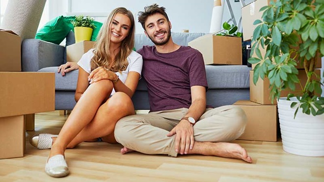 Casal jovem na casa com caixas de mudanças