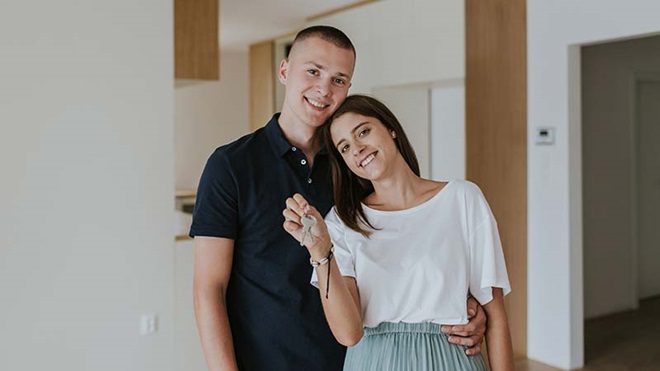 Casal com a chave de casa na mão