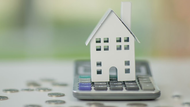 uma casa em cima de uma calculadora e dinheiro à volta em representação de o que é a euribor